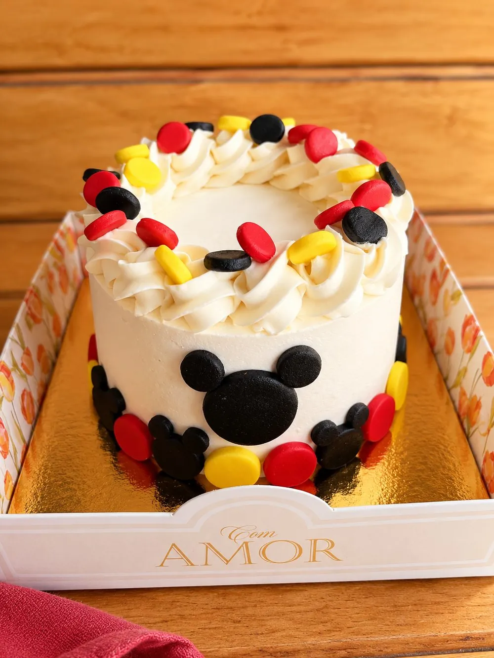 Bentô cake branco decorado em vermelho, amarelo e preto, na caixa Com Amor